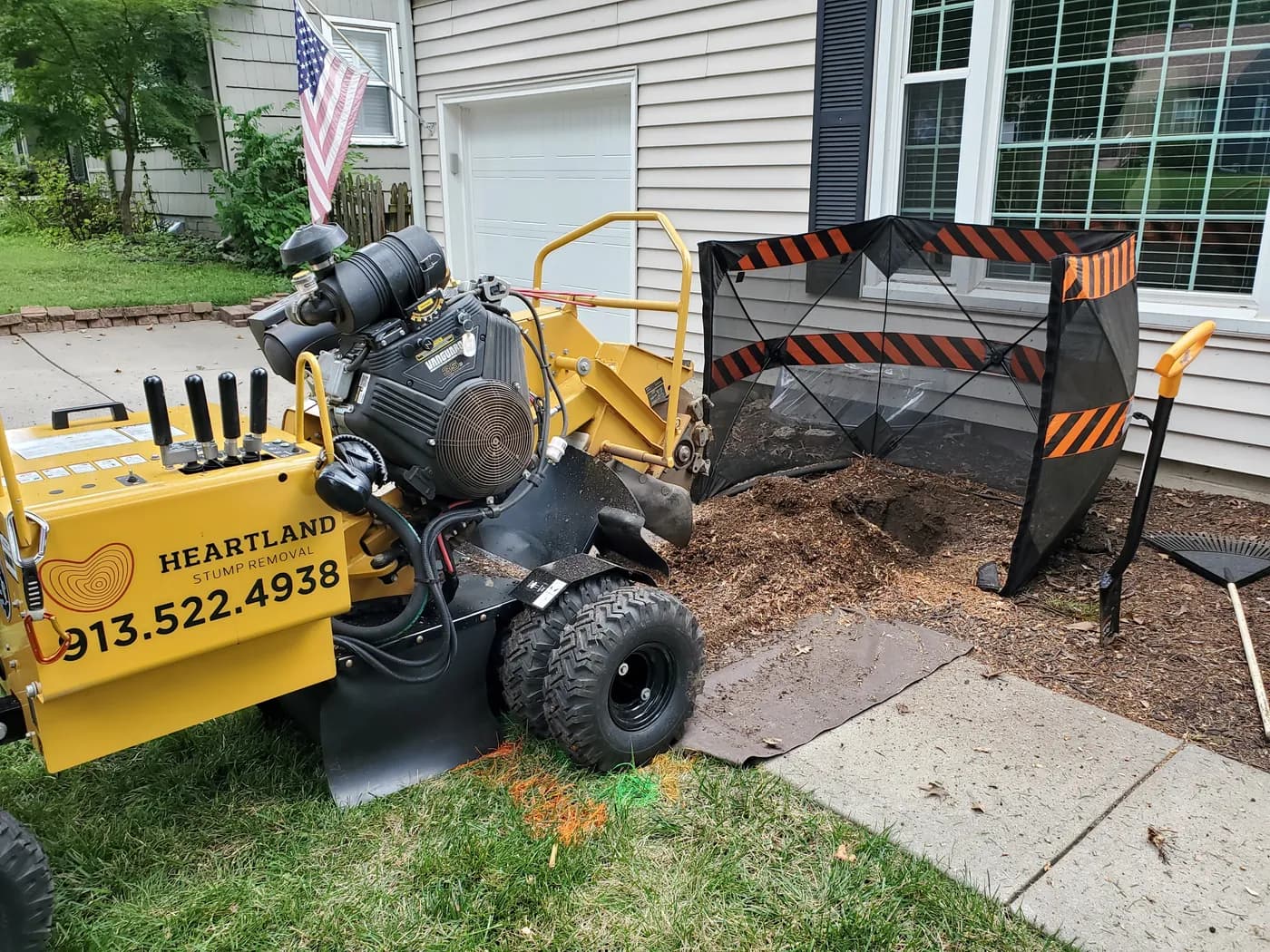 Heartland stump grinder with protective screens beside a home